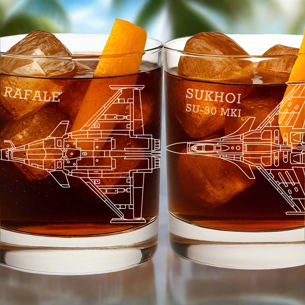 Two glasses with ice cubes and orange slices, featuring airplane illustrations and names 'RAFALE' and 'SUKHOI SU-30 MKI'.