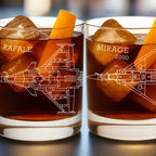 Two whiskey tumblers with aviation-themed designs and text, filled with a dark liquid and ice cubes.