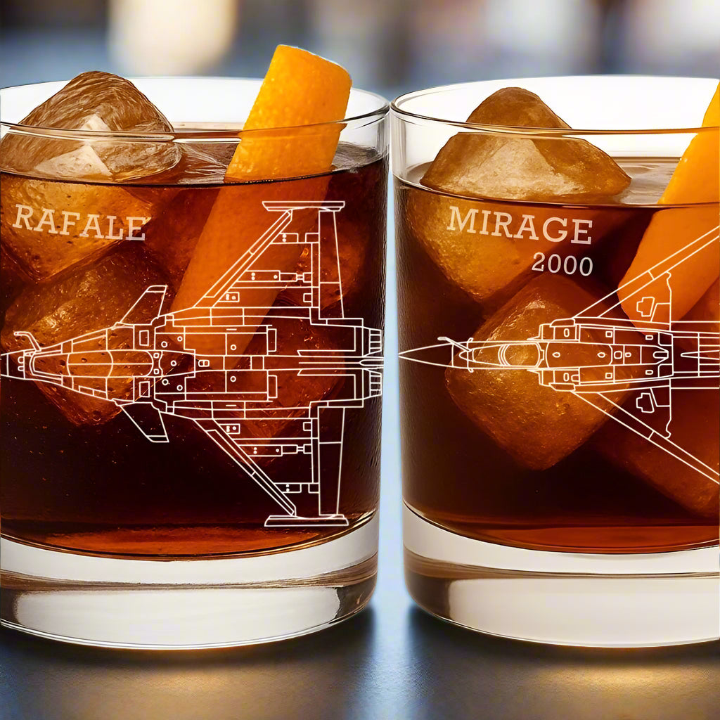 Two whiskey tumblers with aviation-themed designs and text, filled with a dark liquid and ice cubes.