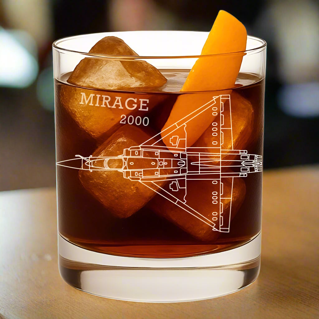Glass of dark liquid with ice and an orange slice, featuring 'Mirage 2000' design.