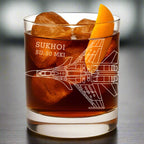 Glass with a Sukhoi SU-30 MKI design, filled with a bourbon cocktail and ice cubes.