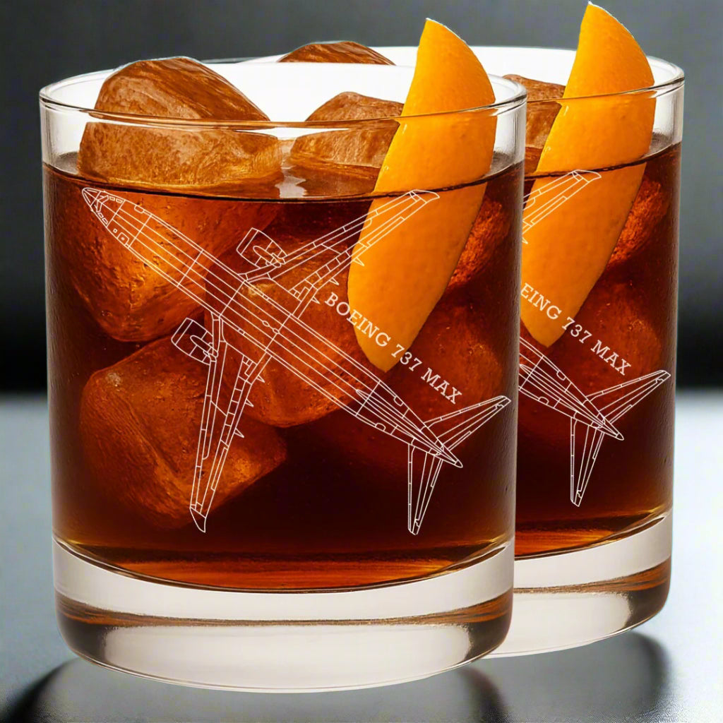 Two glasses of a brown liquid with orange slices and airplane boeing 737 Max engraved.