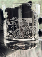 Clear glass tumbler with a detailed black and white illustration of a s400 launcher on a blurred background