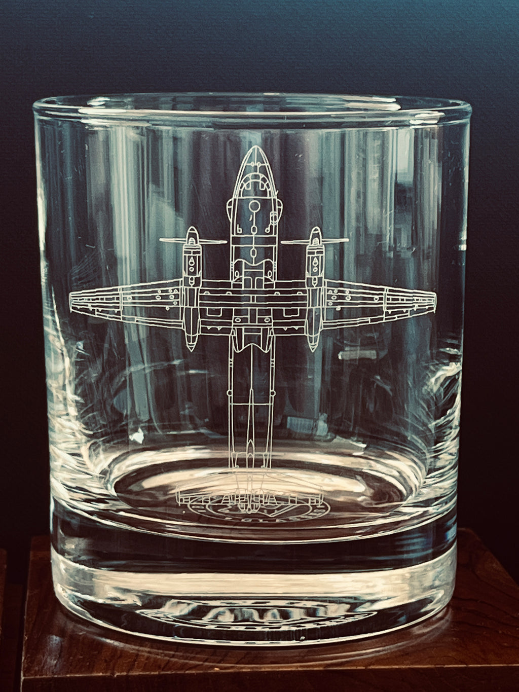 Clear glass tumbler with an engraved antonov an-32 airplane design on a dark background