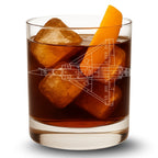 Glass of iced drink with an orange slice and airplane blueprint, on a white background
