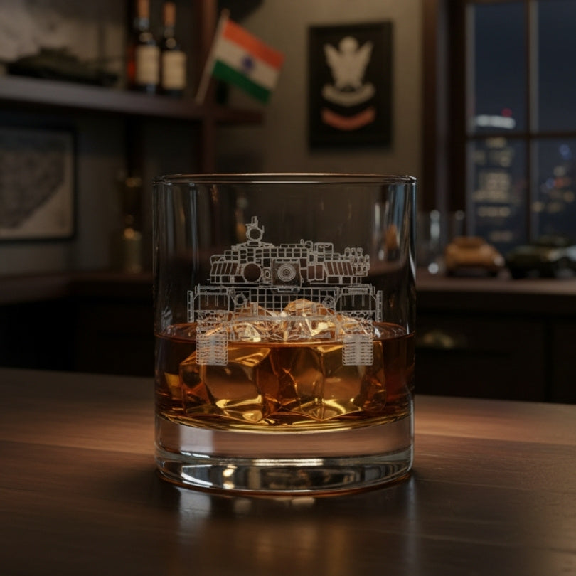 Glass of whiskey with an engraved T-72 tank design on a wooden table, blurred background