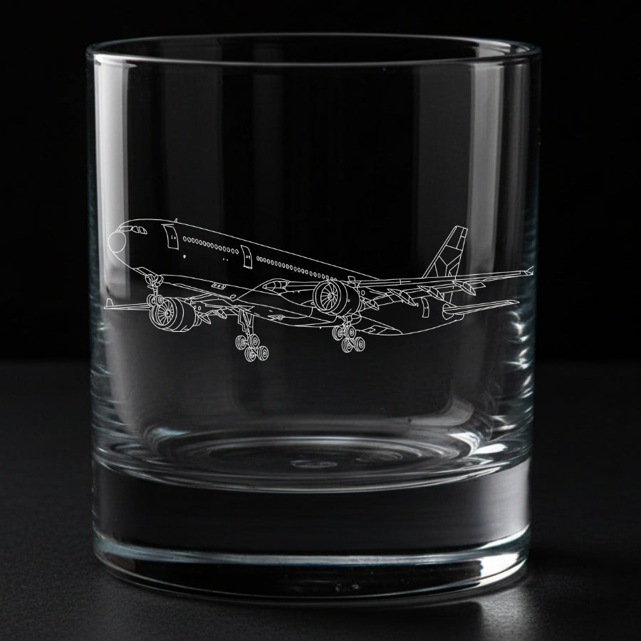 A clear glass rocks tumbler with an etched outline of a airbus A330 commercial airplane on the side, shown against a solid black background.
