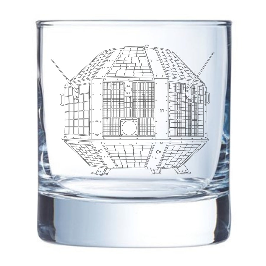 A clear glass rocks tumbler with an etched line drawing of india's first satellite - the aryabhata from ISRO