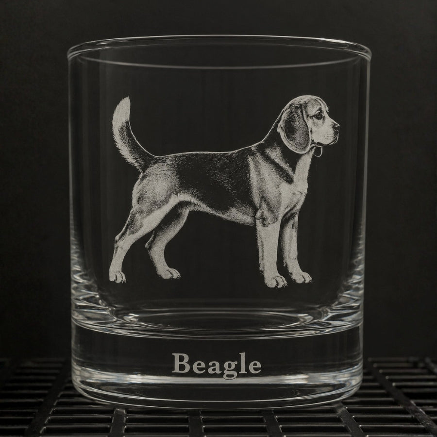 A clear glass rocks tumbler with an etched beagle dog illustration and the word 'Beagle' at the base, shown against a dark background.