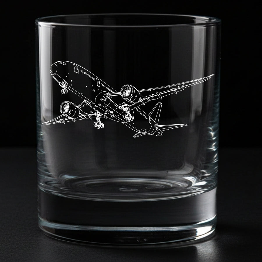 A clear glass rocks tumbler with an etched white line drawing of a commercial 787 dreamliner airplane, shown against a solid black background.