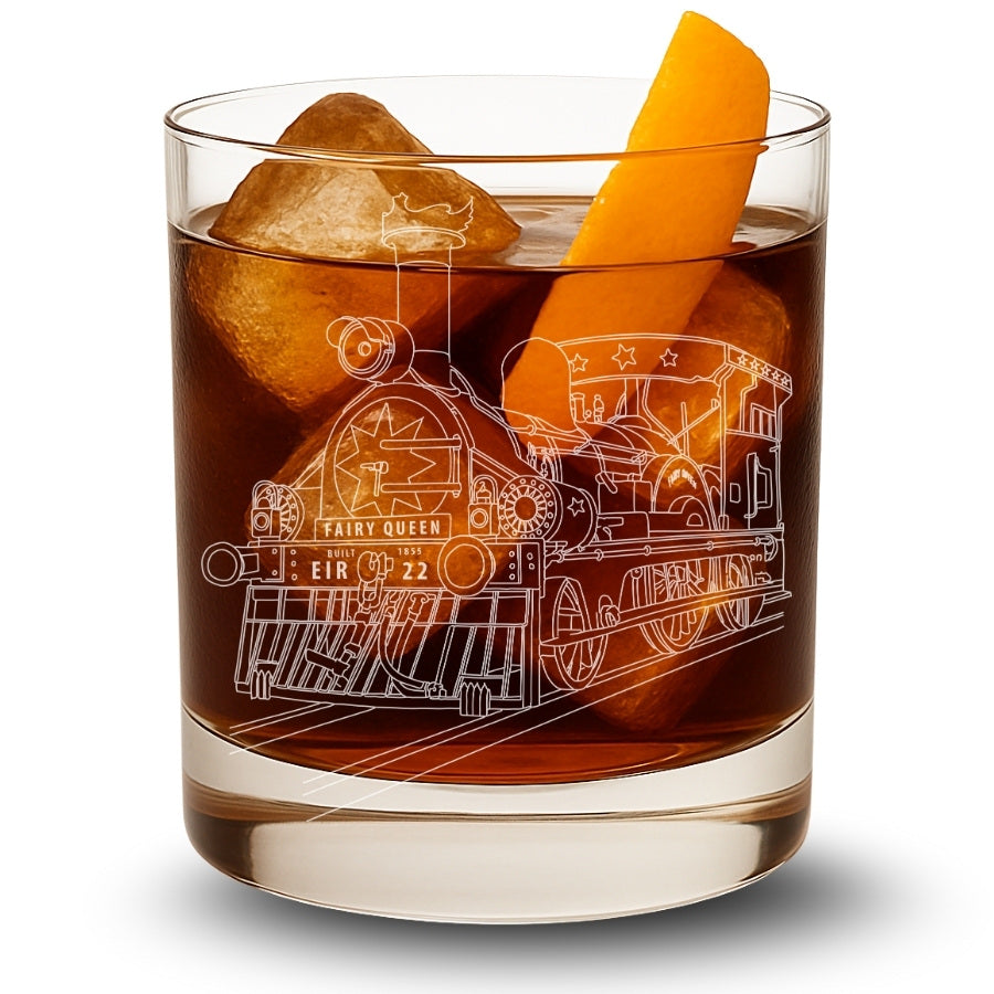 a whiskey glass with a cocktail and engraved with the indian railways and worlds oldest running steam locomotive - the fairy queen