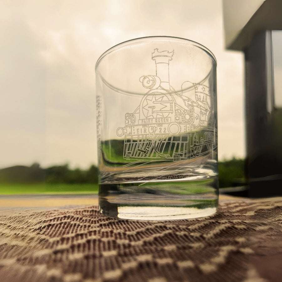 a whiskey glass engraved with the indian railways and worlds oldest running steam locomotive - the fairy queen