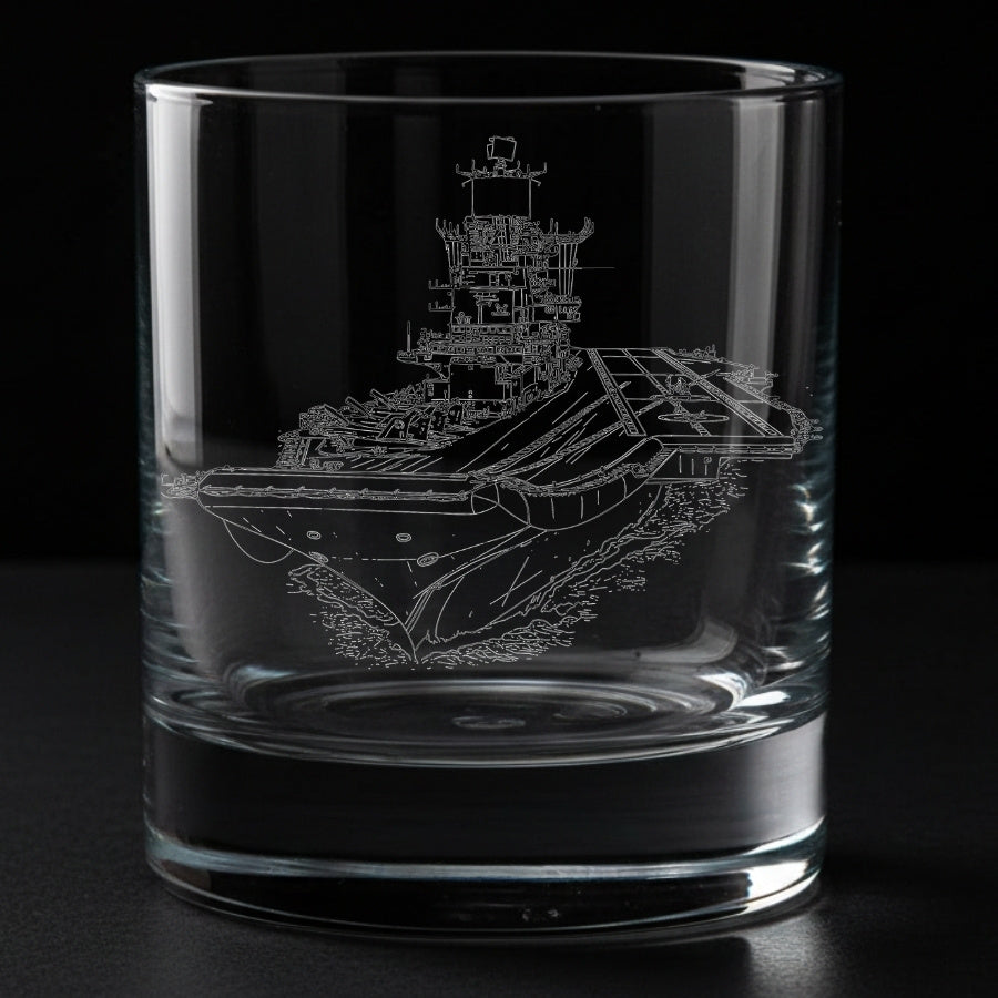 Clear glass tumbler with an engraved aircraft carrier ship INS Vikramaditya design on a black background