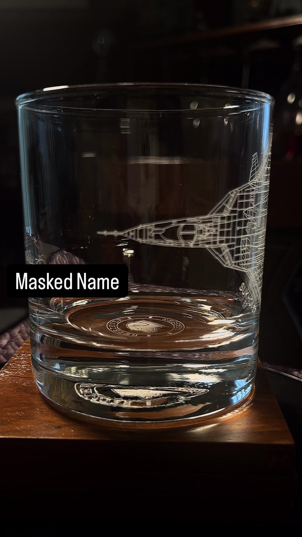 whiskey glass with an etched su-57 on a rotating table